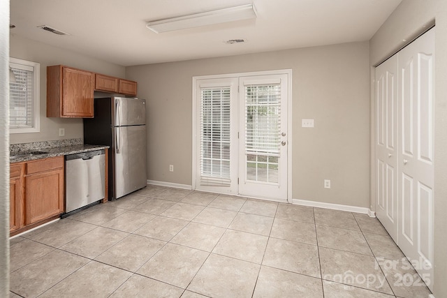 8432 Spirea Ct, Charlotte, NC 28215 - kitchen with stainless steel appliances, light tile patterned flooring, dark stone countertops, and baseboards