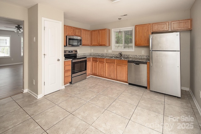 8432 Spirea Ct, Charlotte, NC 28215 - kitchen with stainless steel appliances, a sink, ceiling fan, dark stone countertops, and baseboards