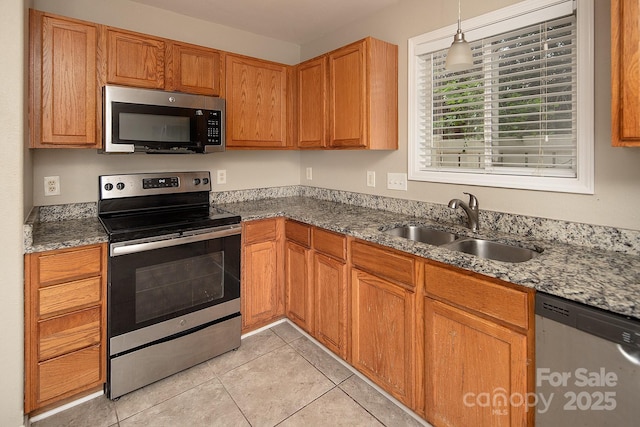 8432 Spirea Ct, Charlotte, NC 28215 - kitchen featuring stainless steel appliances, a sink, light tile patterned flooring, and stone counters