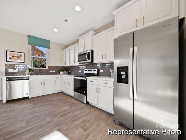 205 Cliffwood St NW Unit Unita-1, Concord, NC 28027 - kitchen with stainless steel appliances, white cabinetry, backsplash, light countertops, and recessed lighting