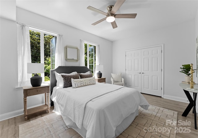 300 W Fifth St Unit 509, Charlotte, NC 28202 - bedroom with a ceiling fan, a closet, wood finished floors, and baseboards