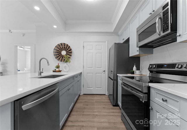 300 W Fifth St Unit 509, Charlotte, NC 28202 - kitchen featuring appliances with stainless steel finishes, a raised ceiling, a sink, ornamental molding, and recessed lighting