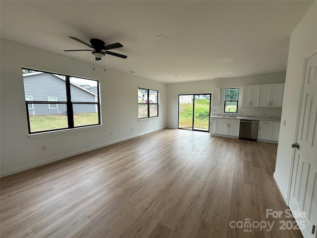 804 3rd Street Pl SW, Hickory, NC 28602 - unfurnished living room with light wood-style flooring, baseboards, a ceiling fan, and a sink
