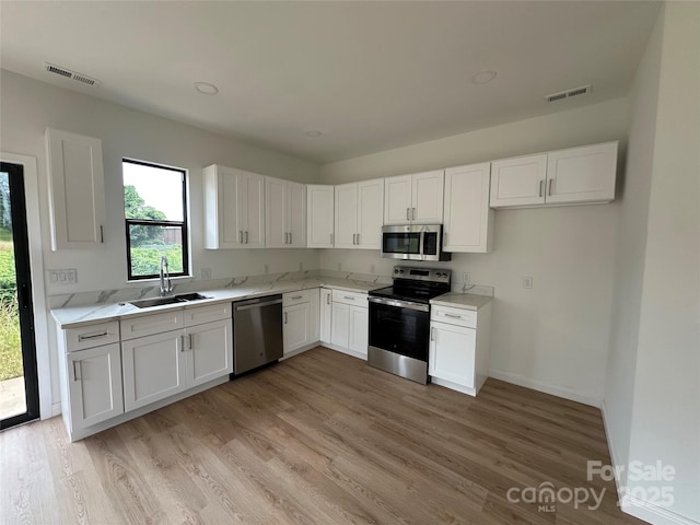 804 3rd Street Pl SW, Hickory, NC 28602 - kitchen featuring appliances with stainless steel finishes, a sink, white cabinets, and light wood-style floors