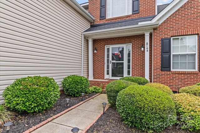 108 Planters Dr, Statesville, NC 28677 - doorway to property featuring roof with shingles and brick siding
