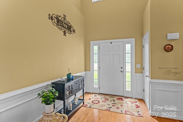 108 Planters Dr, Statesville, NC 28677 - entryway with a wainscoted wall, wood finished floors, healthy amount of natural light, a decorative wall, and a towering ceiling