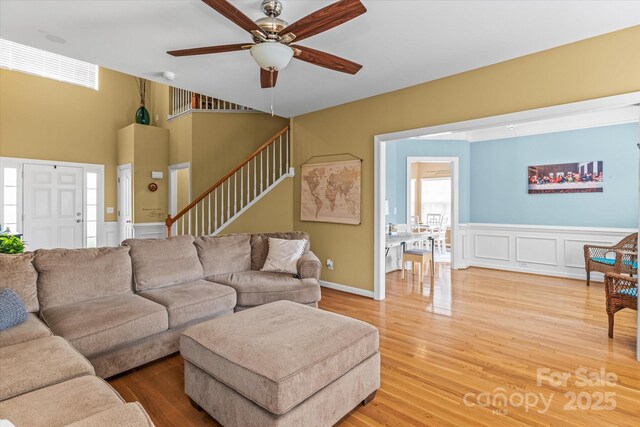 108 Planters Dr, Statesville, NC 28677 - living area with stairs, a ceiling fan, wood finished floors, wainscoting, and a towering ceiling