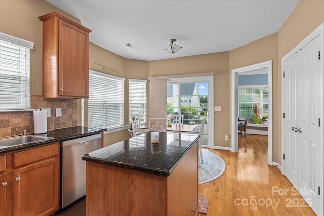 108 Planters Dr, Statesville, NC 28677 - kitchen with dishwasher, light wood-style floors, a kitchen island, decorative backsplash, and brown cabinets
