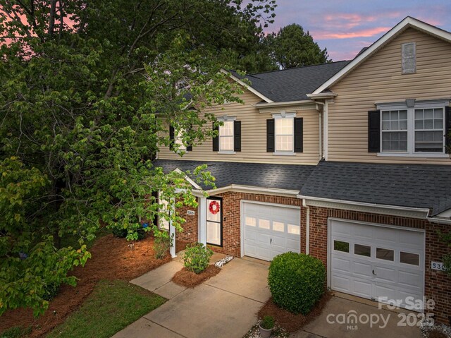 5305 Waverly Lynn Ln Unit 4A, Charlotte, NC 28269 - view of front facade with a shingled roof, driveway, brick siding, and an attached garage