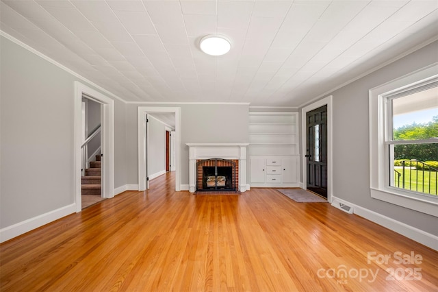 983 Stroud Rd, Ellenboro, NC 28040 - unfurnished living room with crown molding, a fireplace, light wood-style floors, stairs, and baseboards