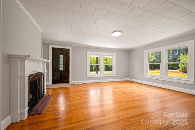 983 Stroud Rd, Ellenboro, NC 28040 - unfurnished living room with crown molding, a fireplace with flush hearth, light wood-type flooring, and baseboards