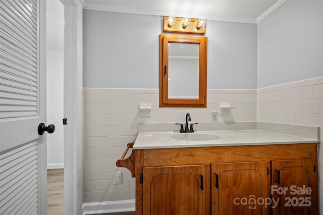 983 Stroud Rd, Ellenboro, NC 28040 - bathroom featuring vanity, tile walls, ornamental molding, wood finished floors, and a wainscoted wall