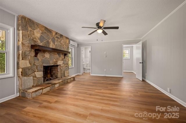 983 Stroud Rd, Ellenboro, NC 28040 - unfurnished living room featuring wood finished floors, an AC wall unit, crown molding, plenty of natural light, and a textured ceiling