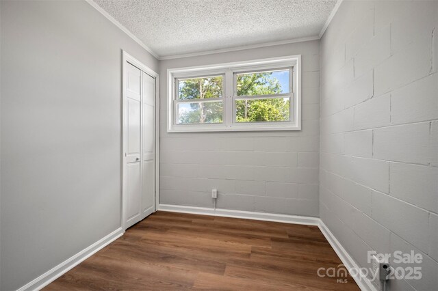 983 Stroud Rd, Ellenboro, NC 28040 - unfurnished bedroom with crown molding, dark wood-style floors, a closet, a textured ceiling, and baseboards