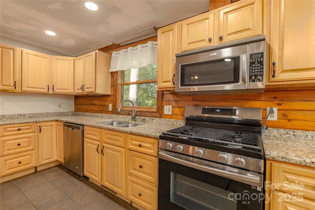 95 Idlewood Dr, Marion, NC 28752 - kitchen featuring appliances with stainless steel finishes, a sink, vaulted ceiling, tile patterned flooring, and light stone countertops