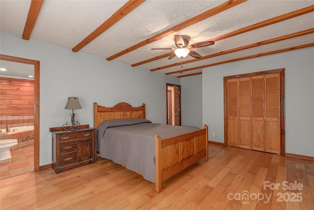 95 Idlewood Dr, Marion, NC 28752 - bedroom with light wood finished floors, ensuite bath, beam ceiling, a closet, and baseboards