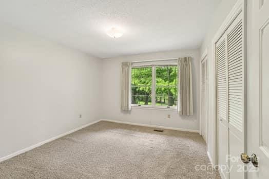 125 Merrill Rd, Fletcher, NC 28732 - unfurnished bedroom with baseboards, carpet floors, and a closet
