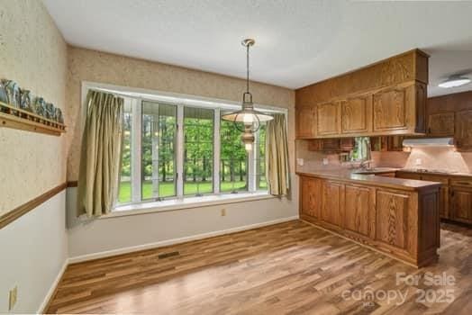 125 Merrill Rd, Fletcher, NC 28732 - kitchen with brown cabinetry, wood finished floors, and baseboards