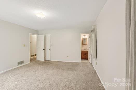 125 Merrill Rd, Fletcher, NC 28732 - unfurnished bedroom featuring carpet flooring, baseboards, and connected bathroom