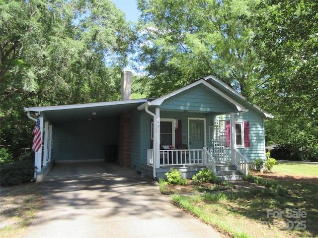 1051 S Brady Ave, Newton, NC 28658 - view of front of home with a porch, a chimney, concrete driveway, and an attached carport