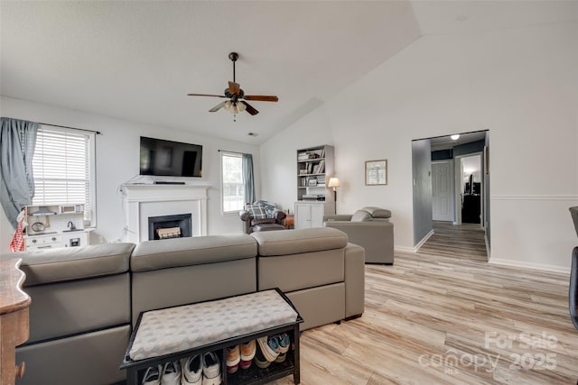4712 Avalon Forest Ln, Charlotte, NC 28269 - living area featuring a ceiling fan, a fireplace, light wood-style floors, baseboards, and high vaulted ceiling