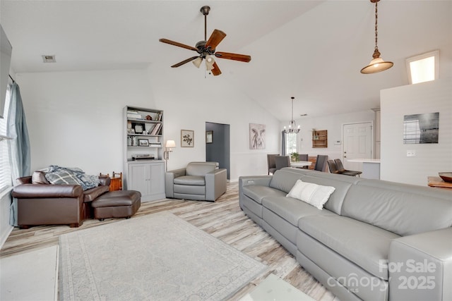 4712 Avalon Forest Ln, Charlotte, NC 28269 - living room featuring light wood-style flooring, a ceiling fan, high vaulted ceiling, a chandelier, and baseboards