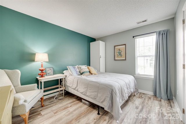 4712 Avalon Forest Ln, Charlotte, NC 28269 - bedroom featuring light wood finished floors, a textured ceiling, and baseboards