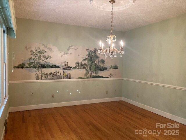 1614 Statesville Blvd, Salisbury, NC 28144 - spare room featuring a textured ceiling, wood finished floors, and a chandelier