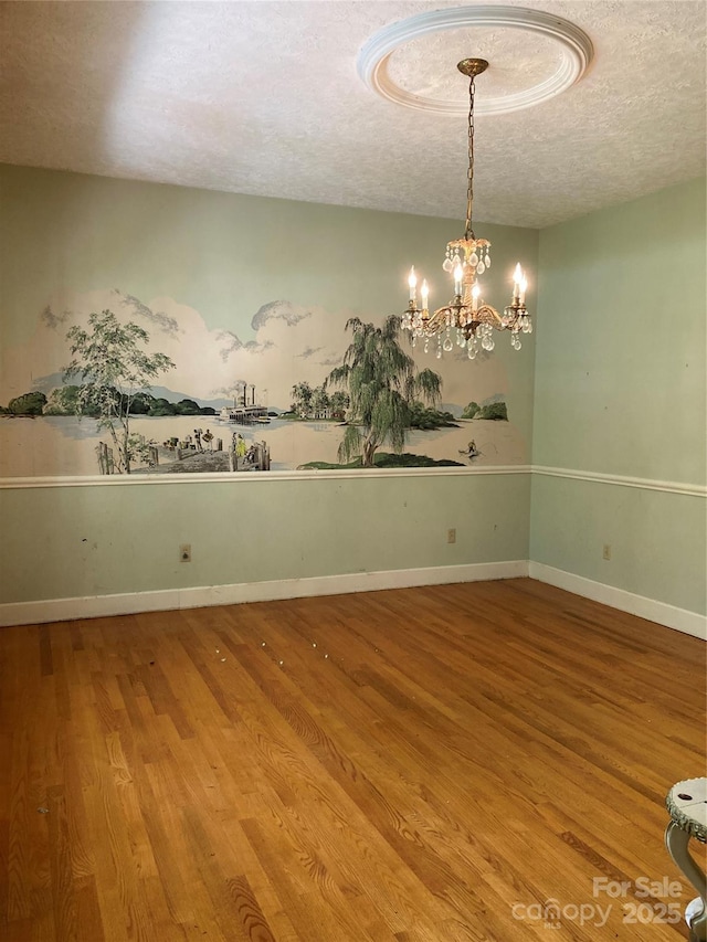 1614 Statesville Blvd, Salisbury, NC 28144 - empty room featuring a textured ceiling, wood finished floors, and a chandelier