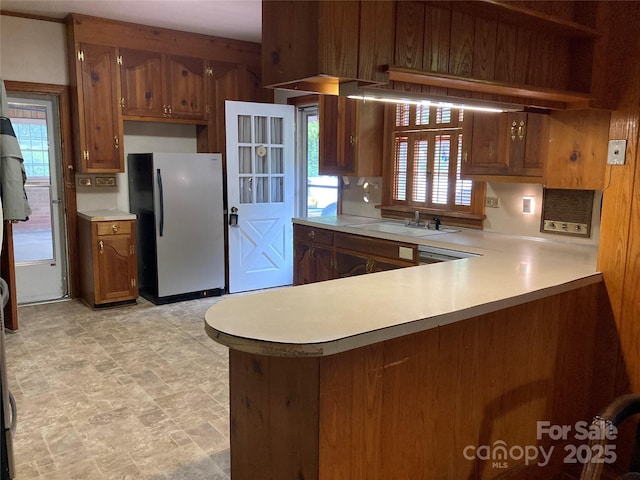 1614 Statesville Blvd, Salisbury, NC 28144 - kitchen featuring freestanding refrigerator, light countertops, a peninsula, and brown cabinetry