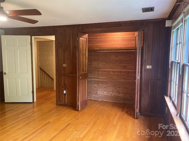 1614 Statesville Blvd, Salisbury, NC 28144 - unfurnished bedroom with wooden walls, light wood-style flooring, a closet, and ceiling fan
