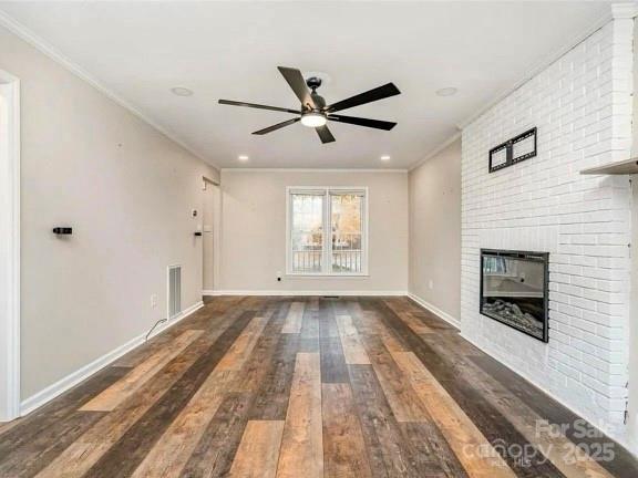 3572 Heather Ln, Gastonia, NC 28056 - unfurnished living room featuring a ceiling fan, wood finished floors, ornamental molding, a brick fireplace, and baseboards