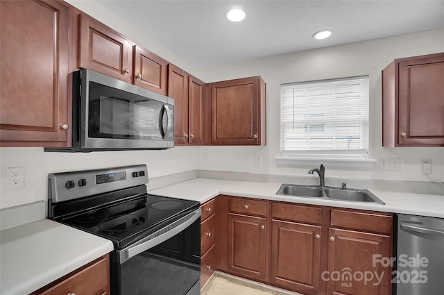 5237 Ficus Tree Ln, Charlotte, NC 28215 - kitchen with appliances with stainless steel finishes, light countertops, a textured ceiling, recessed lighting, and light tile patterned floors