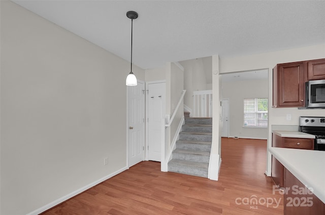 5237 Ficus Tree Ln, Charlotte, NC 28215 - kitchen featuring stainless steel appliances, light wood-style flooring, light countertops, and decorative light fixtures