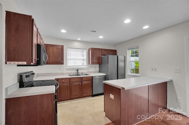 5237 Ficus Tree Ln, Charlotte, NC 28215 - kitchen featuring appliances with stainless steel finishes, a peninsula, light countertops, and recessed lighting