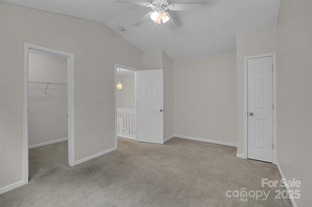 5237 Ficus Tree Ln, Charlotte, NC 28215 - unfurnished bedroom featuring carpet floors, a walk in closet, a closet, vaulted ceiling, and ceiling fan