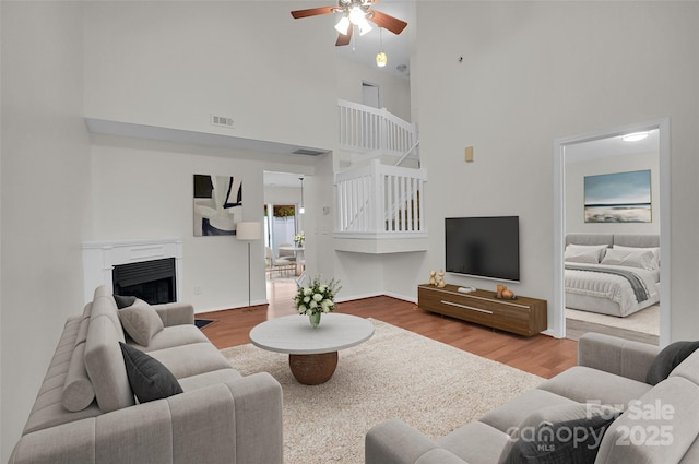 5237 Ficus Tree Ln, Charlotte, NC 28215 - living room with a towering ceiling, a ceiling fan, wood finished floors, and a fireplace