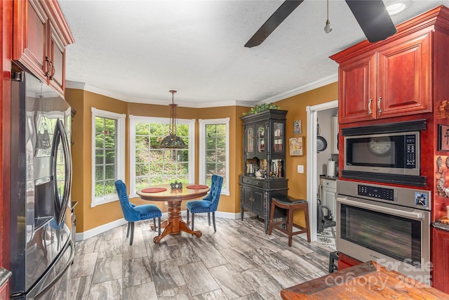 1706 Rock House Cove Rd, Clyde, NC 28721 - dining space featuring baseboards, a ceiling fan, a textured ceiling, and crown molding