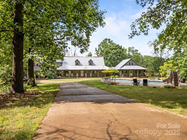 1433 Kern Carlton Rd, Salisbury, NC 28146 - view of front of house with an outdoor pool, a front lawn, a metal roof, and concrete driveway