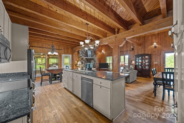 1433 Kern Carlton Rd, Salisbury, NC 28146 - kitchen with a chandelier, appliances with stainless steel finishes, wooden walls, open floor plan, and plenty of natural light