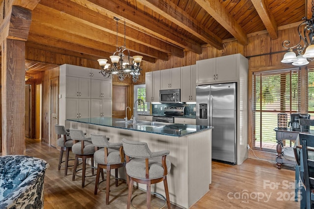 1433 Kern Carlton Rd, Salisbury, NC 28146 - kitchen with stainless steel appliances, a chandelier, a wooden ceiling with exposed beams, wood walls, and wood finished floors