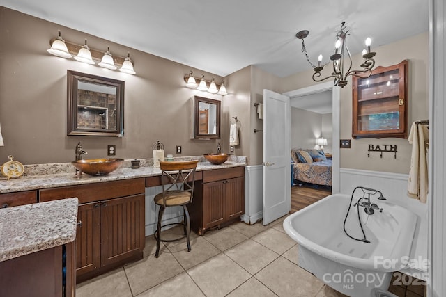 1433 Kern Carlton Rd, Salisbury, NC 28146 - ensuite bathroom featuring a soaking tub, double vanity, wainscoting, tile patterned floors, and a chandelier