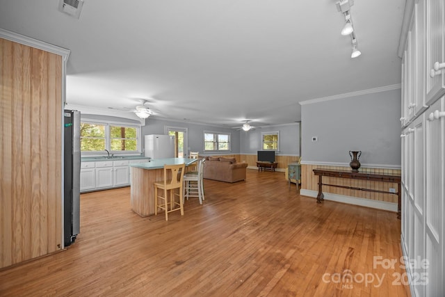 1433 Kern Carlton Rd, Salisbury, NC 28146 - kitchen with ceiling fan, a kitchen island, a kitchen breakfast bar, freestanding refrigerator, and light wood-type flooring