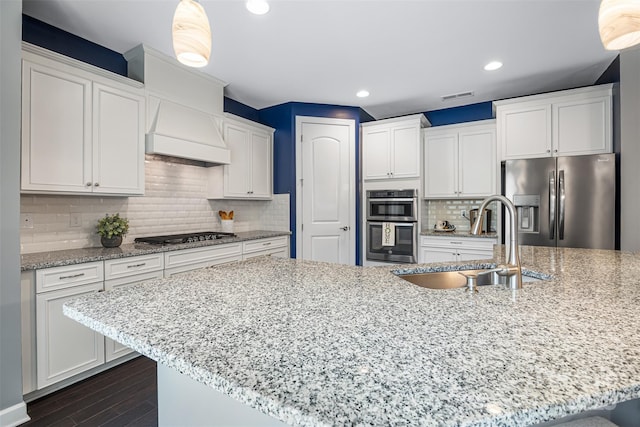 1284 Independence St, Fort Mill, SC 29708 - kitchen with appliances with stainless steel finishes, a sink, premium range hood, white cabinets, and dark wood-style flooring