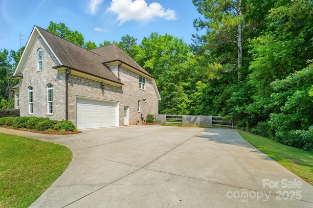 7006 Nesbit Rd, Waxhaw, NC 28173 - view of home's exterior featuring driveway, a garage, brick siding, and roof with shingles
