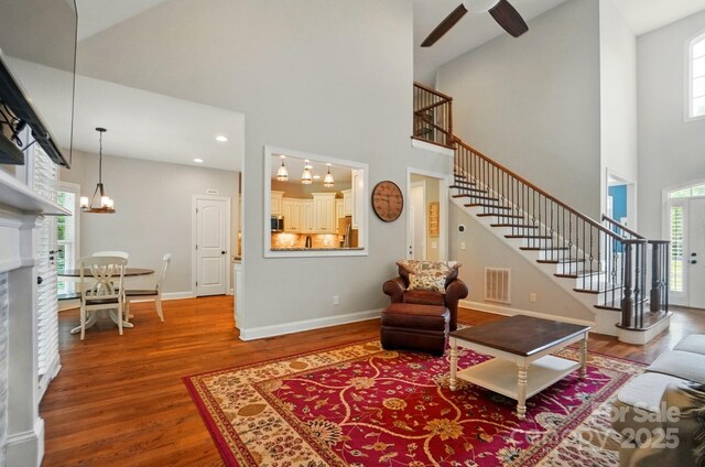 7006 Nesbit Rd, Waxhaw, NC 28173 - living room featuring stairway, a towering ceiling, wood finished floors, plenty of natural light, and ceiling fan