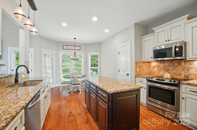 7006 Nesbit Rd, Waxhaw, NC 28173 - kitchen with stainless steel appliances, a sink, light wood-type flooring, white cabinets, and recessed lighting