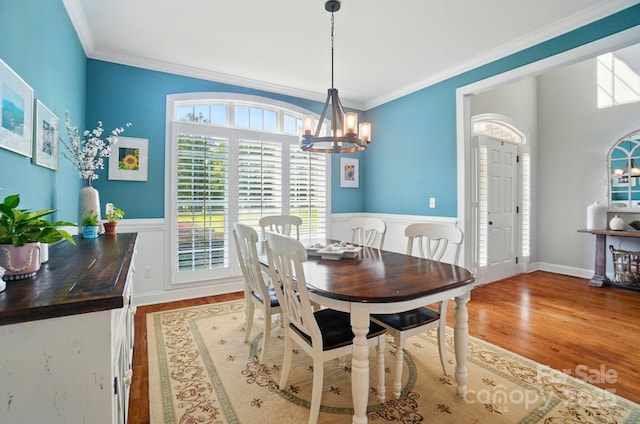 7006 Nesbit Rd, Waxhaw, NC 28173 - dining room with a chandelier, wood finished floors, ornamental molding, wainscoting, and healthy amount of natural light