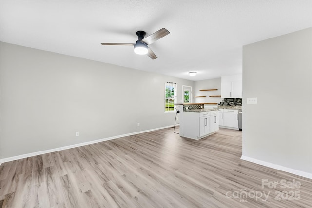 103A N Tracy St, Kings Mountain, NC 28086 - unfurnished living room featuring light wood-style flooring, ceiling fan, and baseboards