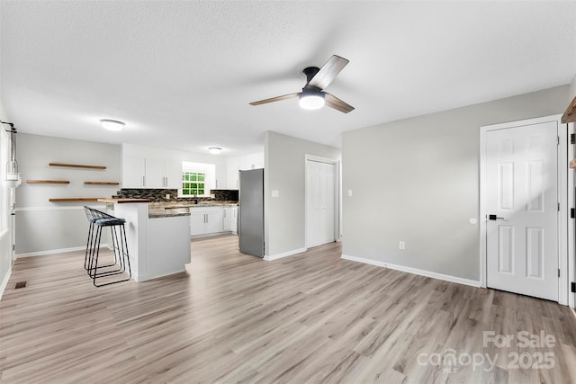 103A N Tracy St, Kings Mountain, NC 28086 - kitchen featuring freestanding refrigerator, white cabinetry, light wood-style flooring, a ceiling fan, and baseboards